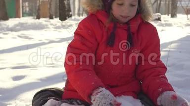 快乐的孩子在冬天的雪地里<strong>玩耍</strong>。 穿着暖和的衣服在冬天的<strong>公园</strong>里散步和<strong>玩耍</strong>的小女孩